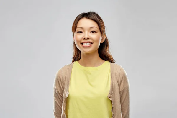 Happy asian woman over grey background — Stock Photo, Image