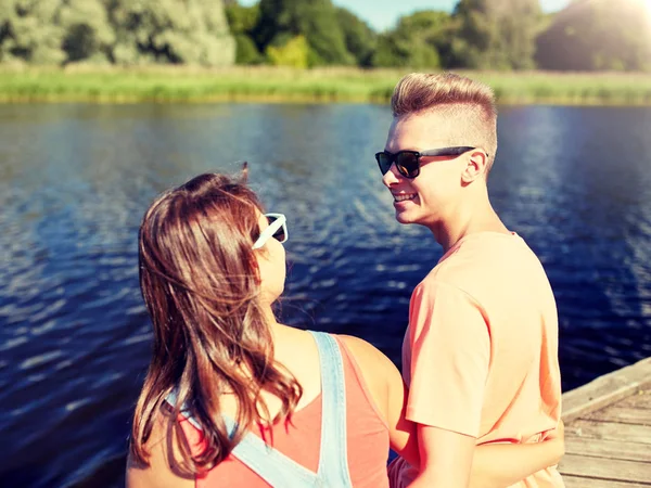 Lycklig tonåring par sitter på flod kaj — Stockfoto