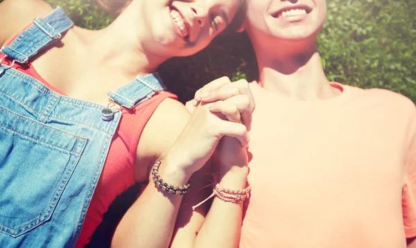 Happy teenage couple lying on grass at summer — Stock Photo, Image