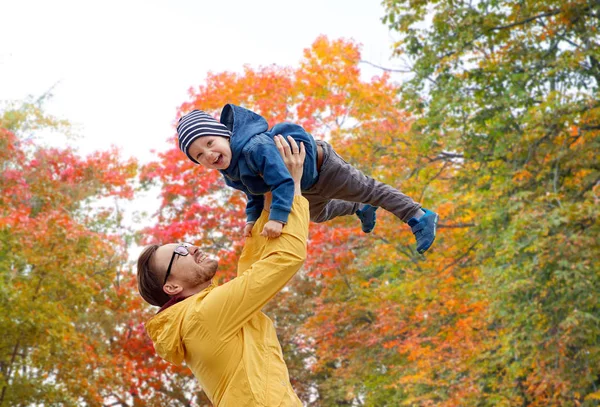 Padre con hijo jugando y divirtiéndose en otoño — Foto de Stock