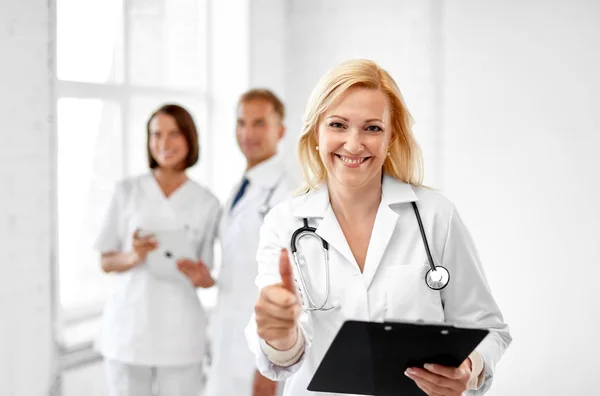 Medico sorridente mostrando pollici in alto in ospedale — Foto Stock