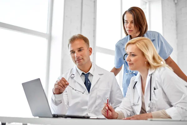 Groep van artsen met laptop computer in het ziekenhuis — Stockfoto