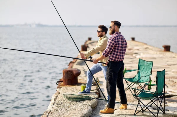 Amigos felizes com varas de pesca no cais — Fotografia de Stock