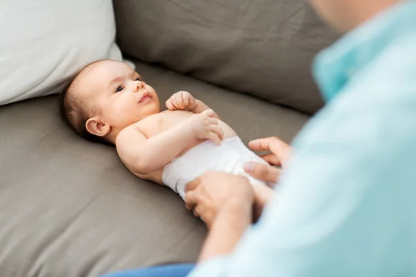 W średnim wieku ojciec zmienia Babys pieluchy w domu — Zdjęcie stockowe