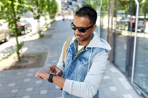 Hombre indio con reloj inteligente y mochila en la ciudad — Foto de Stock