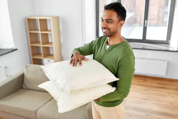 Homme indien avec des coussins de canapé à la nouvelle maison — Photo