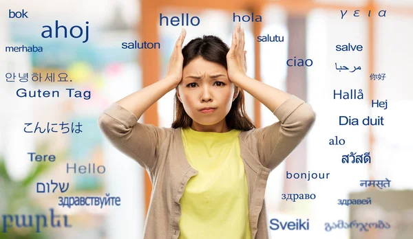 Stressed asian woman over foreign words — Stock Photo, Image