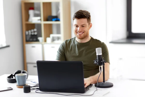 Homme avec ordinateur portable et microphone au bureau à domicile — Photo