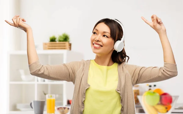 Asiática mulher em fones de ouvido ouvindo música — Fotografia de Stock