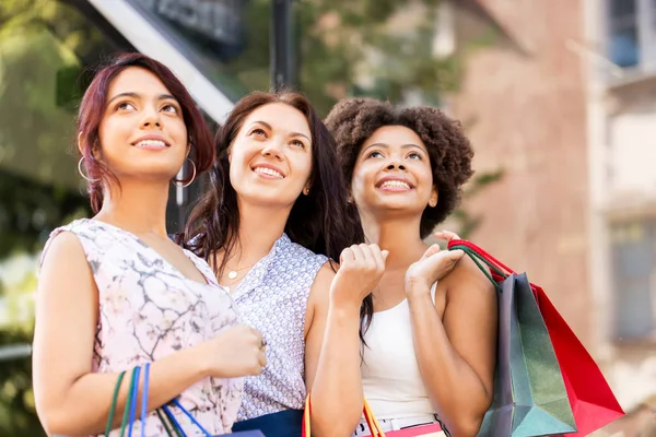 Glada kvinnor med shoppingkassar i city — Stockfoto