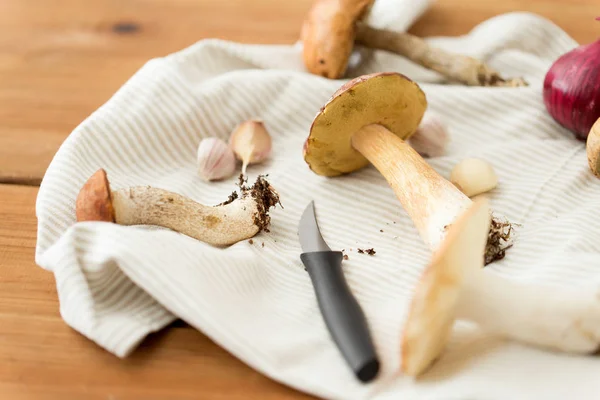 Cogumelos comestíveis, faca de cozinha e toalha — Fotografia de Stock