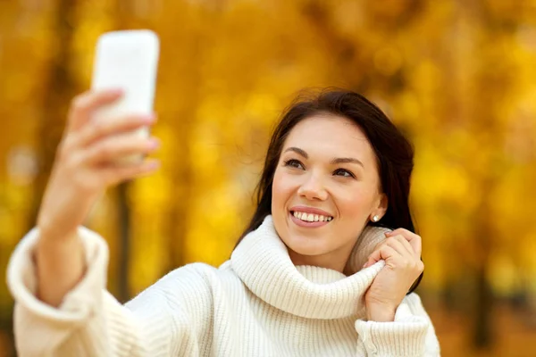 Frau macht Selfie mit Smartphone im Herbstpark — Stockfoto