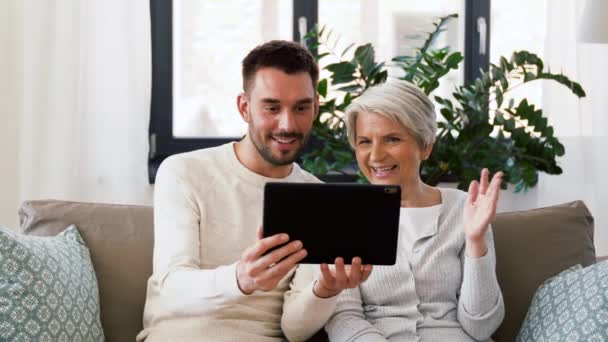 Old mother and adult son with tablet pc at home — Stock Video