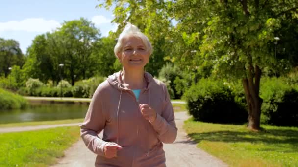 Ηλικιωμένη γυναίκα τρέχει κατά μήκος του θερινού πάρκου — Αρχείο Βίντεο