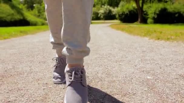 Pieds de vieille femme courant le long de la route du parc d'été — Video