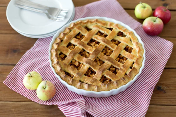 Apple pie in baking mold on wooden table — Stock Photo, Image