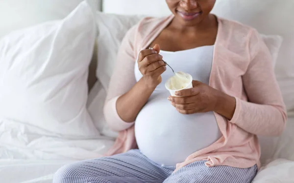Kobieta w ciąży jedzenia jogurt na śniadanie w łóżku — Zdjęcie stockowe