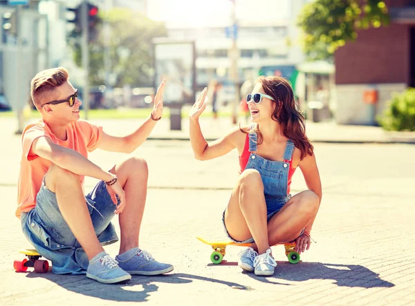 Casal adolescente com skates na rua da cidade — Fotografia de Stock