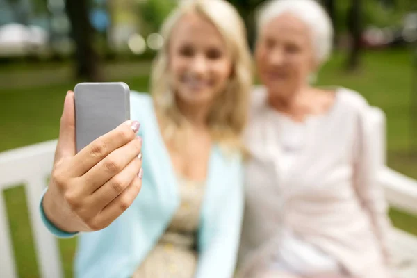 Dotter och senior mor tar selfie på park — Stockfoto
