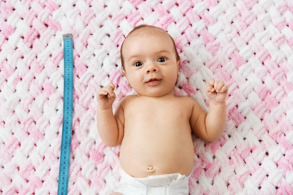 Mädchen liegt mit Maßband auf Decke — Stockfoto