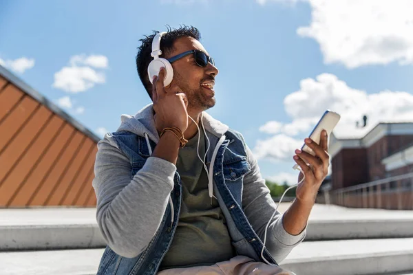 Człowiek ze smartfonem i słuchawkami na dachu — Zdjęcie stockowe