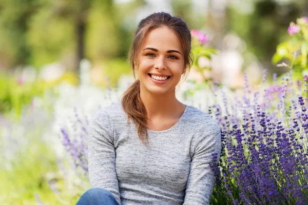 Ung kvinna med blommor på sommaren trädgård — Stockfoto