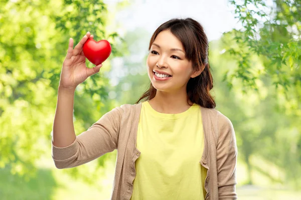 Asiatische Frau mit rotem Herz über natürlichem Hintergrund — Stockfoto