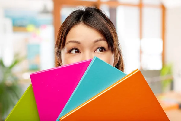 Asiatin oder Studentin versteckt sich hinter Notizbüchern — Stockfoto