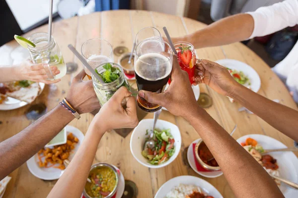 Φίλοι τρώγοντας και τσούγκριζαν ποτήρια εστιατορίου — Φωτογραφία Αρχείου