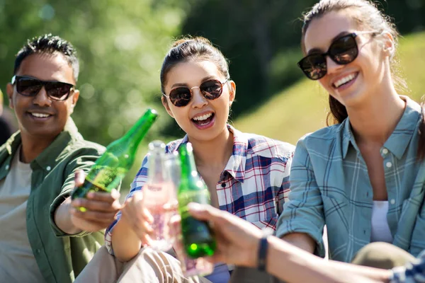 Amis heureux clinking boissons en plein air en été — Photo