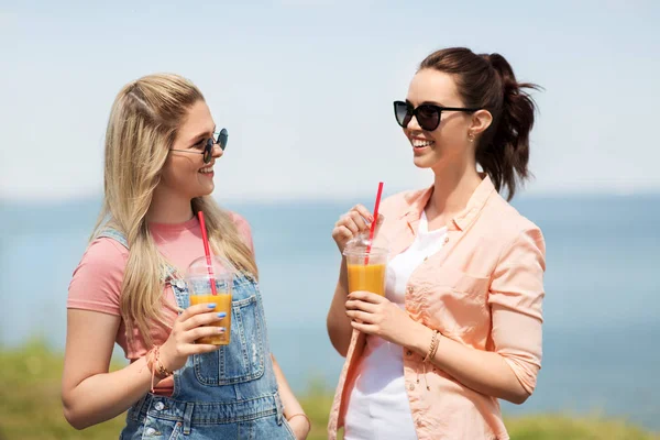 Teenage girls or friends with drinks in summer — Stock Photo, Image