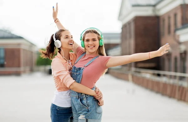 Meninas adolescentes ou amigos em fones de ouvido na cidade — Fotografia de Stock