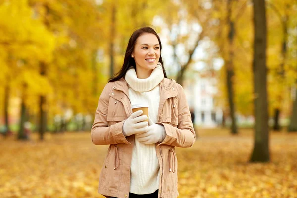 Frau trinkt Kaffee zum Mitnehmen im Herbstpark — Stockfoto