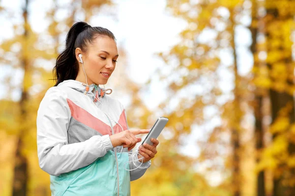 Mujer en el parque de otoño y escuchando música —  Fotos de Stock