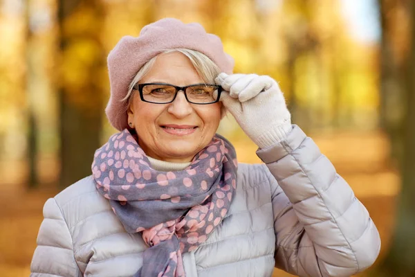 Portret van een vrolijke oudere vrouw in het herfstpark — Stockfoto