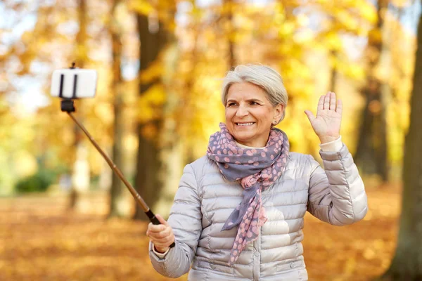 Seniorin macht Selfie im Herbstpark — Stockfoto