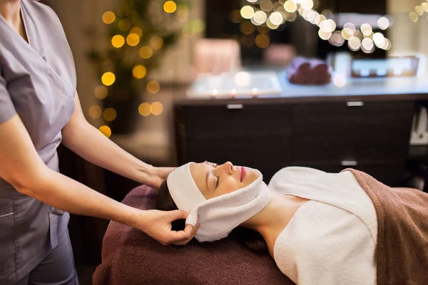 Mulher tendo massagem facial com toalha no salão de spa — Fotografia de Stock