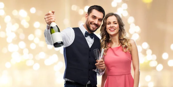 Feliz pareja con botella de champán y copas — Foto de Stock