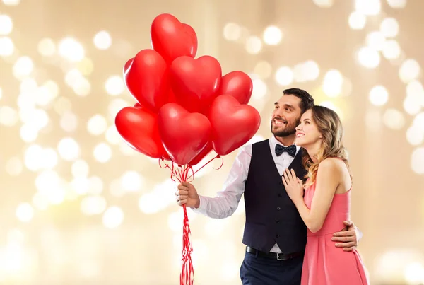 Ευτυχισμένο ζευγάρι με κόκκινη καρδιά σχήμα μπαλόνια — Φωτογραφία Αρχείου