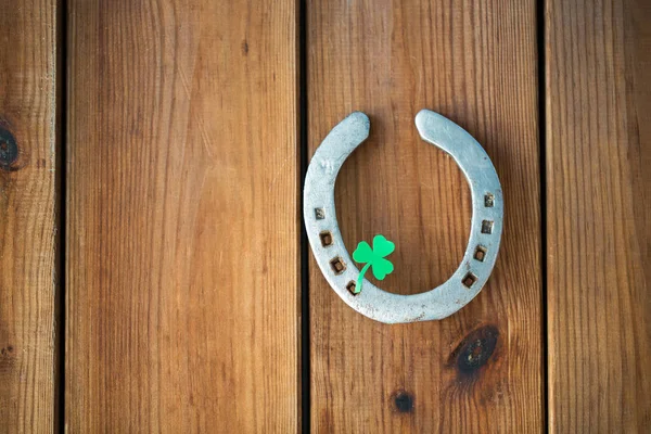 Horseshoe met shamrock op houten achtergrond — Stockfoto