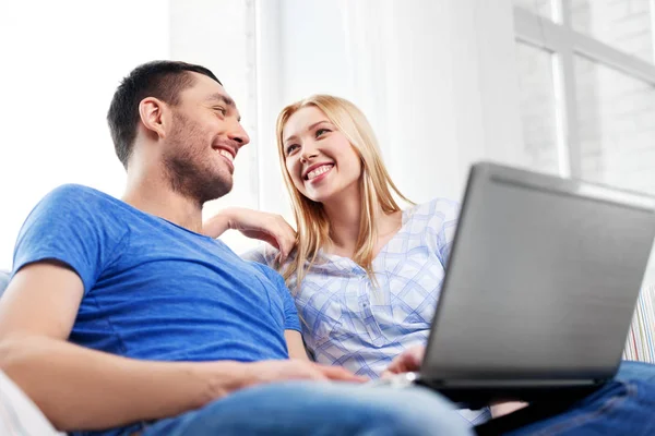 Feliz pareja con ordenador portátil en casa —  Fotos de Stock