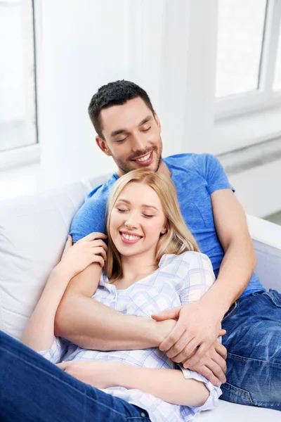 Gelukkige paar zittend op de Bank en knuffelen thuis — Stockfoto