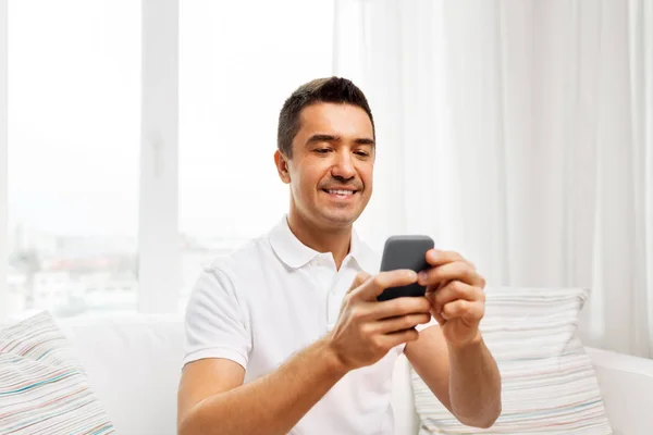 Gelukkig man met smartphone thuis — Stockfoto