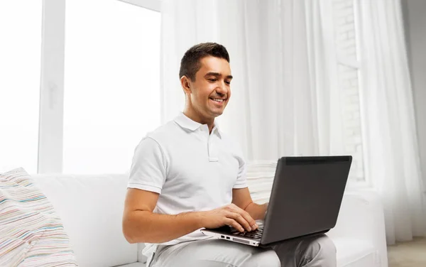 Счастливый человек с ноутбуком дома — стоковое фото