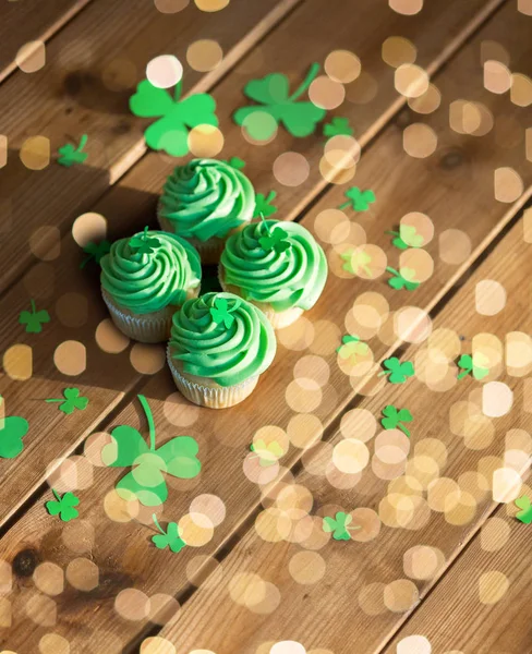 Green cupcakes and shamrock on wooden table — Stock Photo, Image