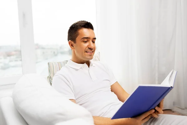 Homem feliz lendo livro em casa — Fotografia de Stock