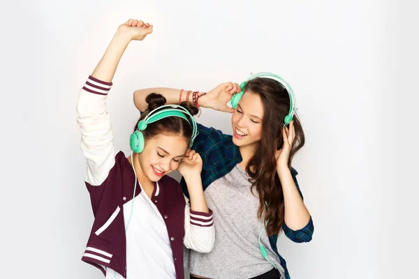 Meninas adolescentes em fones de ouvido ouvindo música — Fotografia de Stock