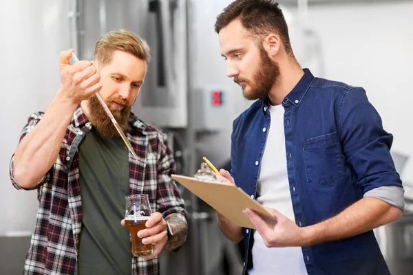 Muži s pipetou testují řemeslné pivo v pivovaru — Stock fotografie