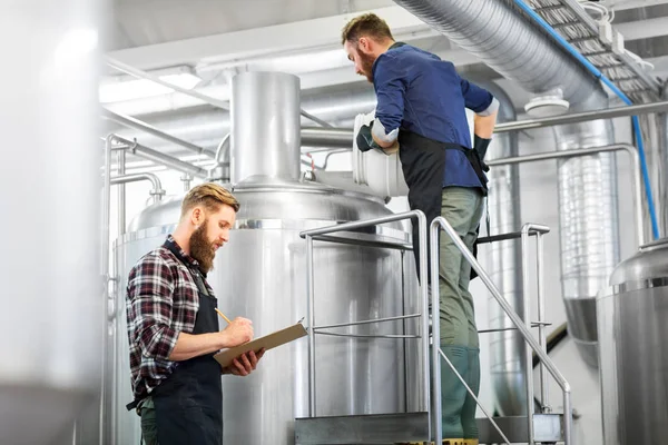 Hombres con portapapeles en la fábrica de cerveza hervidor de agua o planta de cerveza —  Fotos de Stock