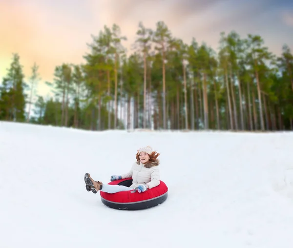 Menina adolescente feliz deslizando para baixo colina no tubo de neve — Fotografia de Stock